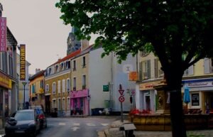 Vue de Saint-Leu-la-Forêt avec ses maisons traditionnelles, rues pavées et la forêt de Montmorency en arrière-plan, reflétant le charme et la tranquillité de la ville