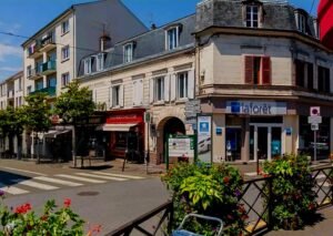 ue de Taverny avec ses espaces verts, bâtiments modernes et la forêt de Montmorency plus loin, illustrant le dynamisme et la verdure de la ville
